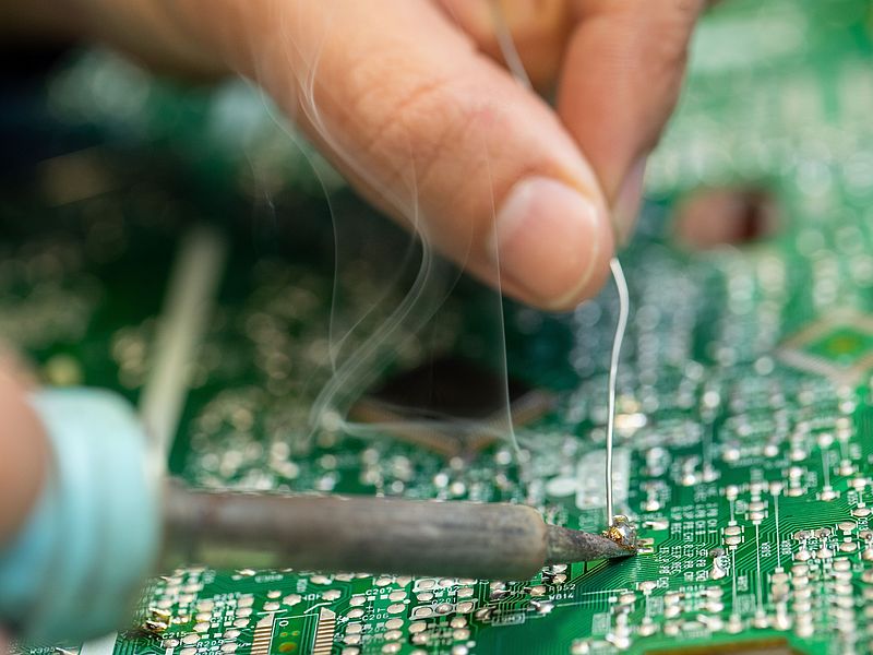 Eine Person lötet eine Platine.