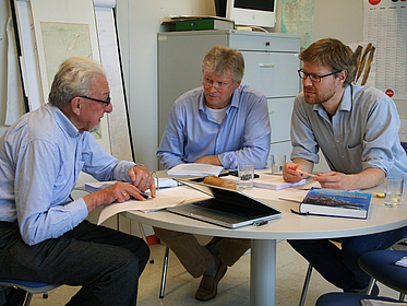 Drei Männer an einem Tisch