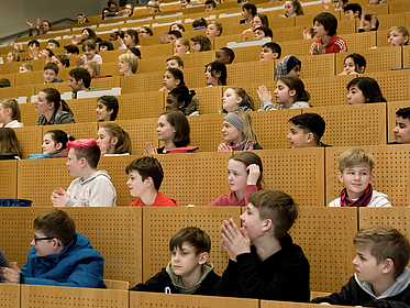 Kinder sitzen im Hörsaal