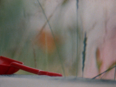 Stil einer roten Spielzeugschaufel vor unscharfem Hintergrund