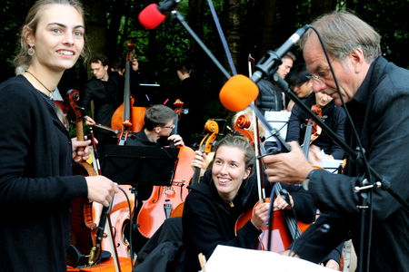 Orchester der Universität Bremen beim Aufbau mit Geigerin und Cellistin