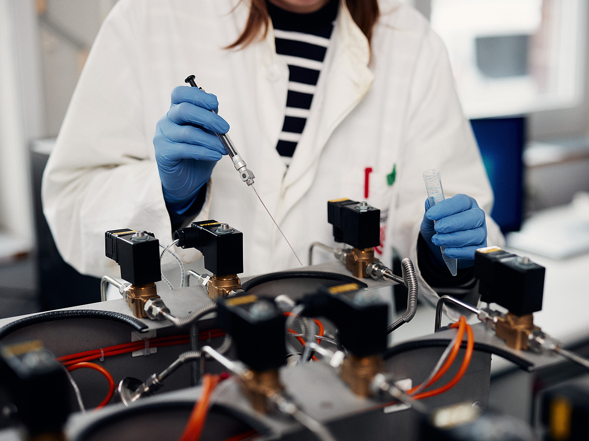 A person injects something into a research device