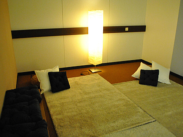 Mit weichen Teppichen und gemütlichen Sitzkissen eingerichteter Raum.