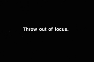 filmstill: schwarze Leinwand mit weissem Text : Throw out of focus