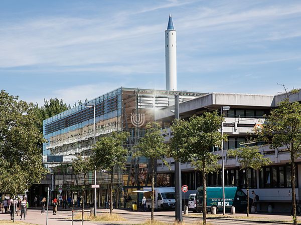 The campus park with glass hall and drop tower in the background.