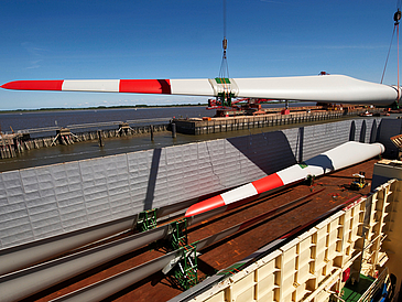 Rotorblätter für Offshore-Windenergieanlage werden auf ein Schiff verladen.