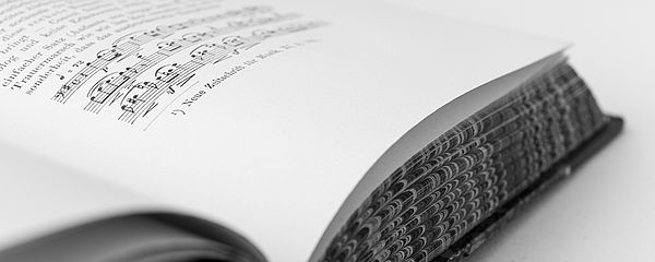 Ein aufgeschlagenes Buch aus dem Archiv liegt auf dem Tisch.