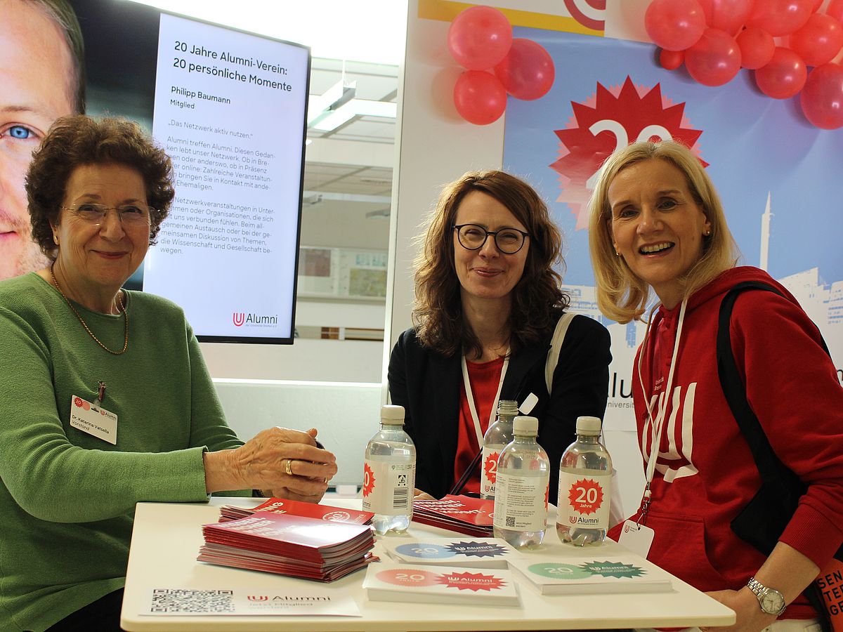 Three people are sitting at a table and looking at the camera; among them are Katherian Vatsella and Jutta Günther