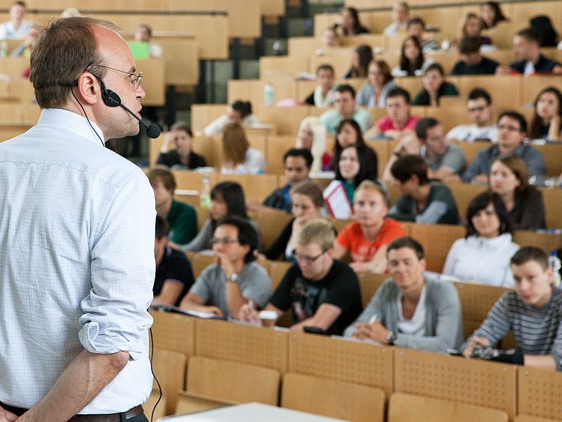 A lecturer in the full lecture hall.