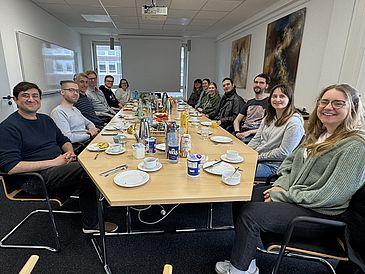 Gruppenfoto am Tisch sitzend
