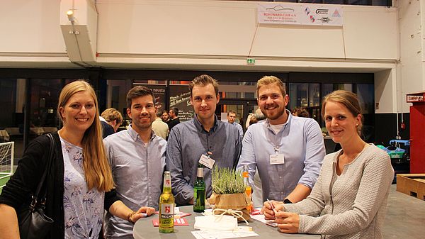 Drei Männer und zwei Frauen lächeln in die Kamera.