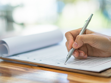 Hand mit Stift uauf einem Formular