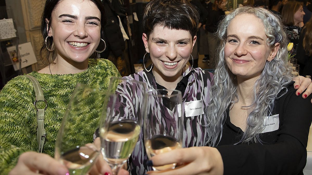 Three happy scholarship holders raise a toast.