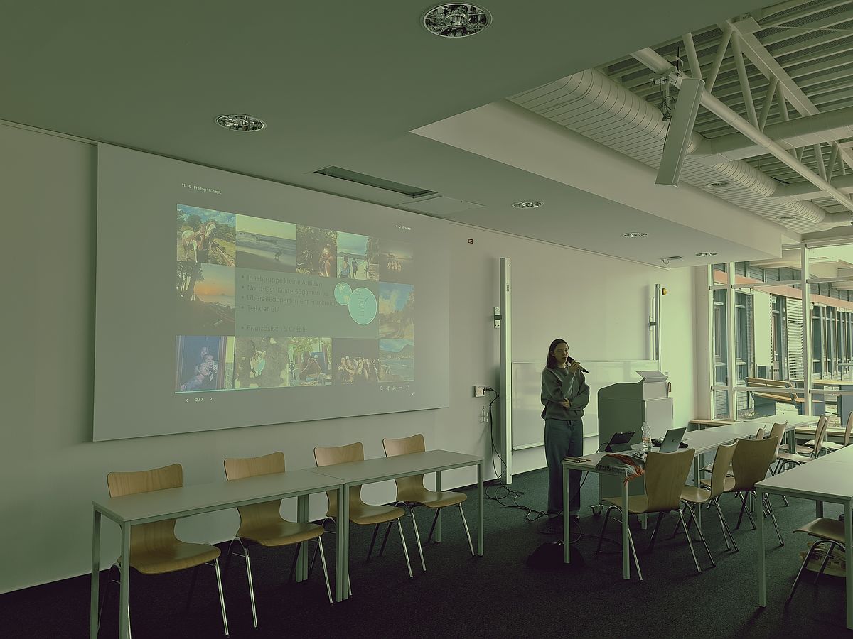 Eine Präsentation wird eingeblendet; eine Studierende referiert.