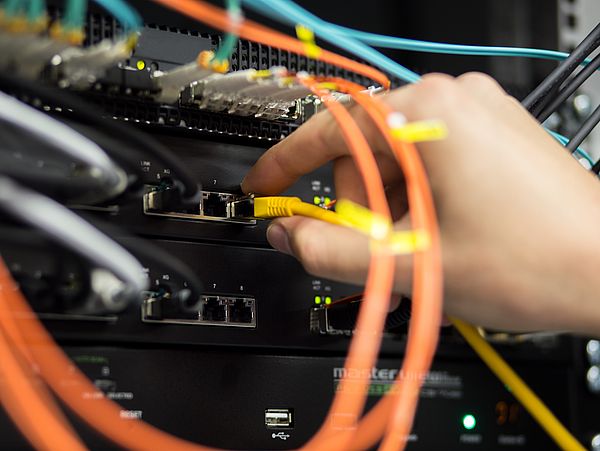 Eine Person befestigt Kabel.