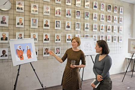 Anna-Lena Vallentin, die das Projekt "aufgezeichnet" koordinierte, im Gespräch mit einer Besucherin vor den ausgestellten Cartoons.