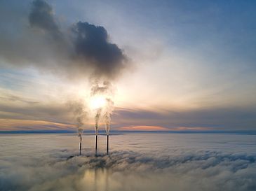 Clouds from which three chimneys emerge before the horizon