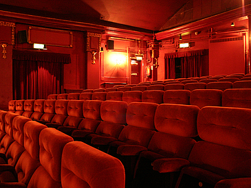 Innenraum eines Kinosaals mit roten Sitzen