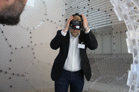 Alumnus setzt Virtual-Reality-Brille auf.