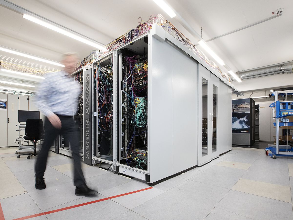 Eine Person läuft an einem Serverschrank vorbei