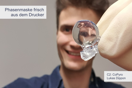 Person mit Linse in der Hand