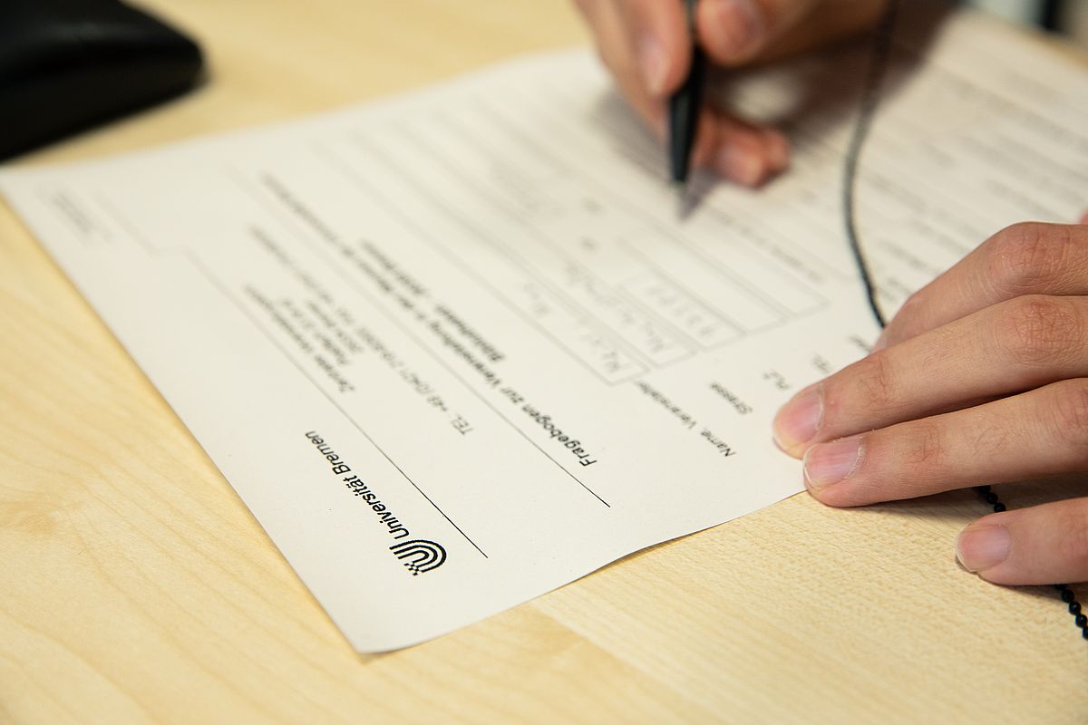 Eine Person füllt einen Fragebogen aus.