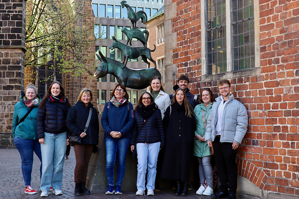Eine Gruppe steht vor den Bremer Stadtmusikanten.