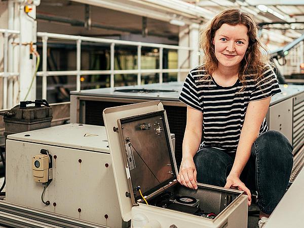 Kezia Lange hockt auf dem Dach der Bremer Straßenbahn 3117 und repariert das selbstkonstruierte Messgerät.