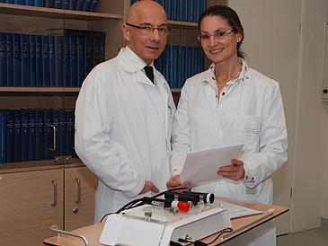Mann und Frau in Arztkittel mit einem Messgerät