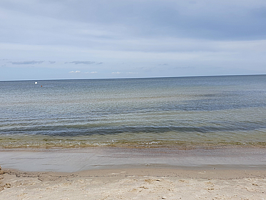 Wellenschlagendes Wasser und bewölkter Himmel