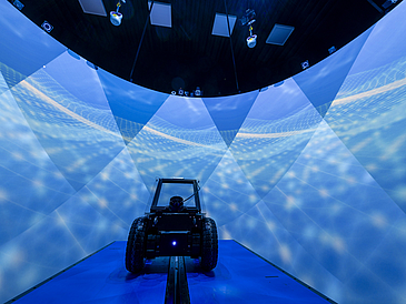 Ein Roboter exploriert eine virtuelle Umgebung und seine Bewegung wird auf einem Laufband umgesetzt, die wiederum in der virtuellen Welt gespiegelt wird.“