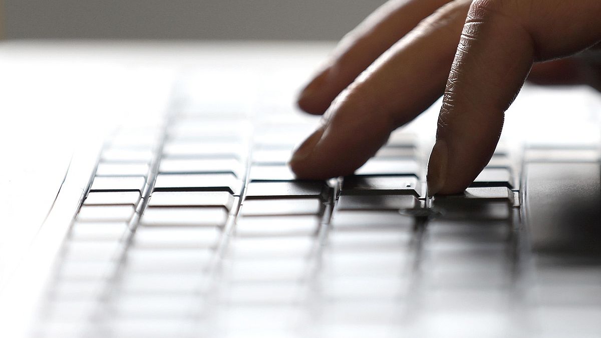 hand typing on a laptop keyboard