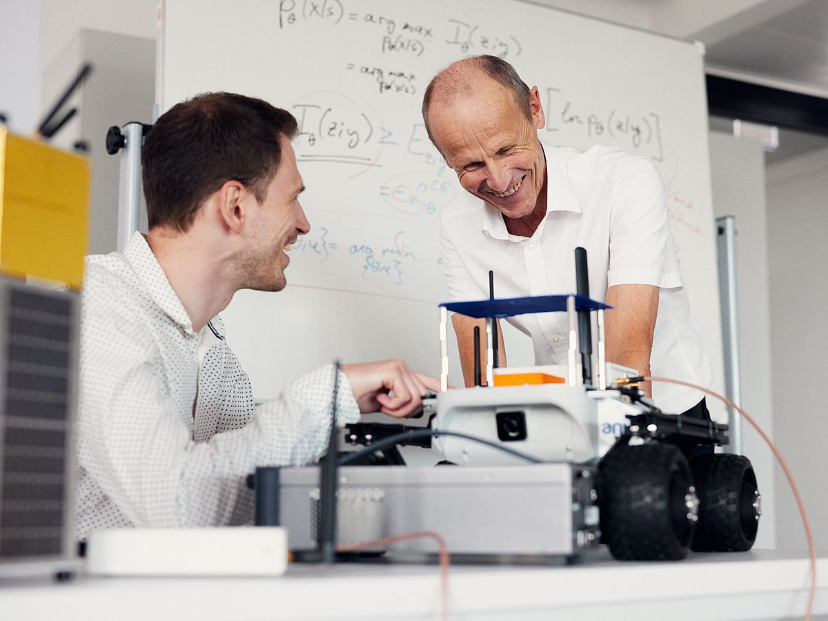 Zwei Männer arbeiten an einem mobilen Roboter