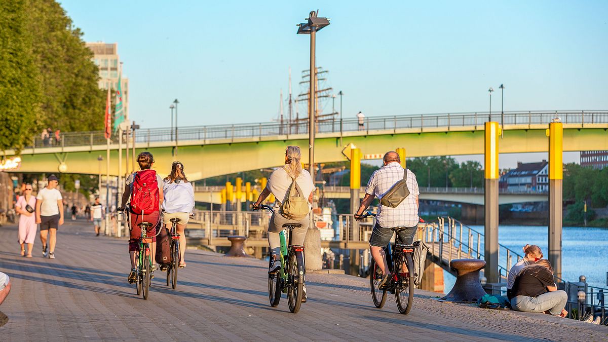 Radfahrer an der Schlachte an der Weser mit Fussgängerbrücke