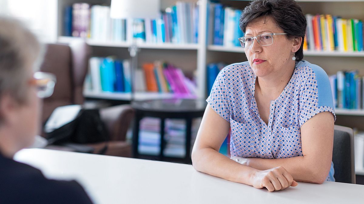 Zwei Frauen im Gespräch an einem Tisch