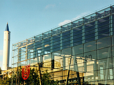 Glashalle mit Fallturm im Hintergrund