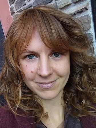 Sophia Otterpohl standing in front of a house wall.