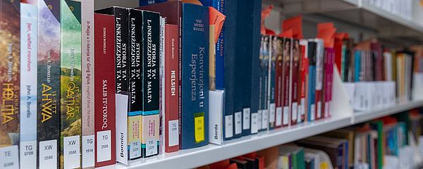 Row of shelves with book spines in the Malta Library