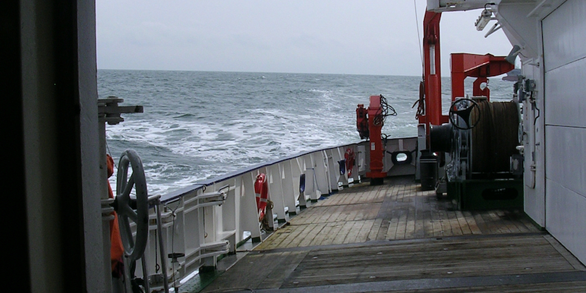 View out of the hangar of the research vessel Heincke onto the rear deck, the ship lies crooked in the waves.