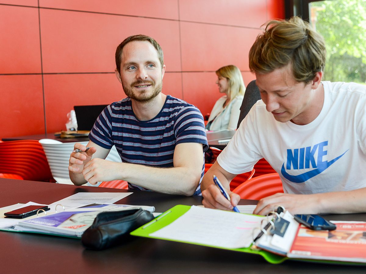 Studierende arbeiten am Tisch.