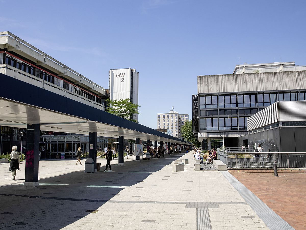 Der Universitäts-Boulevard mit dem GW 2 und der Bibliothek im Hintergrund.