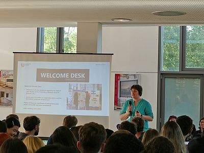 Frau erklärt die Aufgaben des Welcome Desk