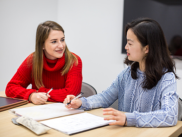Junge Frauen am Schreibtisch.