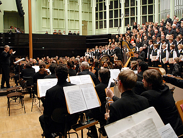 Large orchestra with singers in concert hall