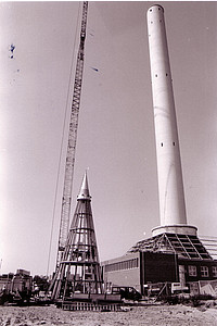 Der Fallturm erhält seine Spitze bevor er 1990 eingeweiht wird.