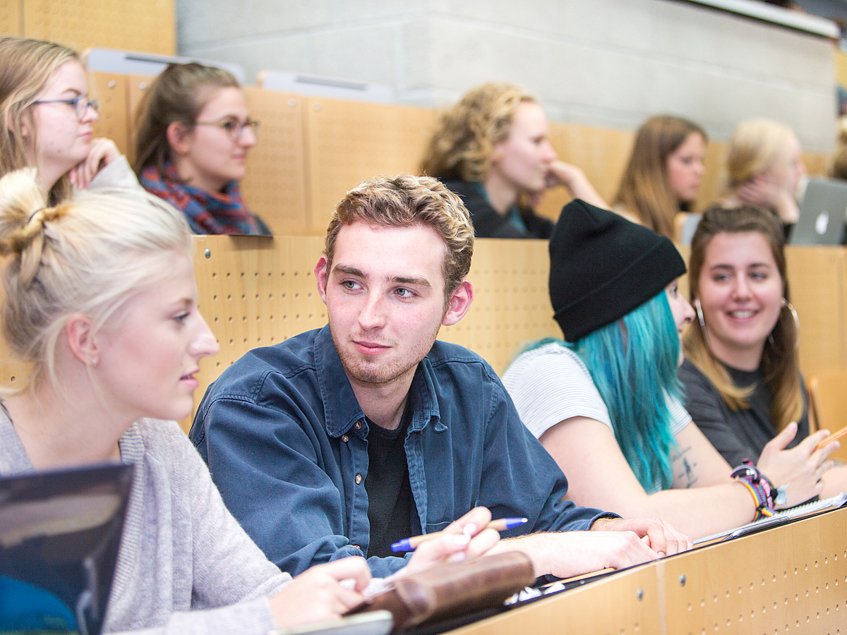 Aufmerksame Zuhörer im vollen Hörsaal.