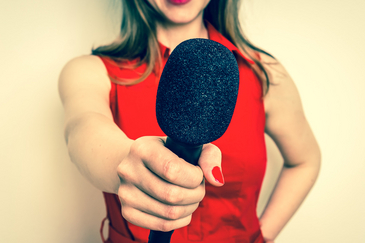 Junge Frau hält ein Mikrofon