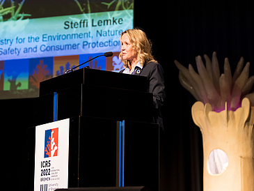 Bundesumweltministerin Steffi Lemke steht an einem Podium und spricht zu den Teilnehmer:innen der 15. Weltkorallenriffkonferenz