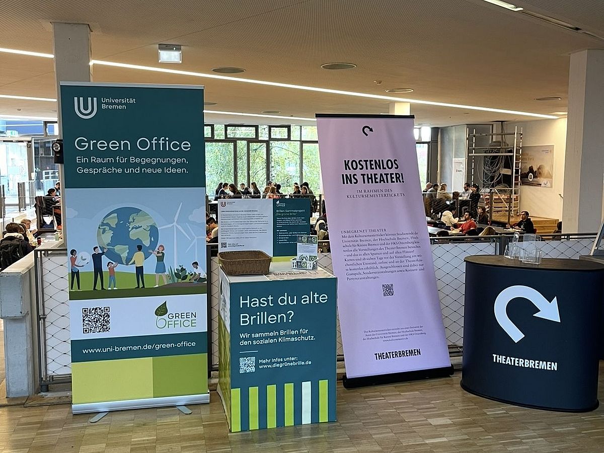 Sammeltisch vom Green Office in der Mensa Sammeltisch vom Green Office in der Mensa. Zudem steht daneben ein Roll-Up vom Green Office in der Mensa und rechts vom Roll-Up und Sammeltisch, steht ein stand und Roll-Up vom Theaterbremen