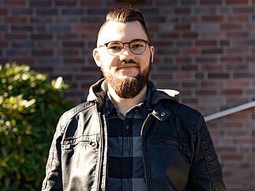 Portraitbild von Jascha de Bloom vor einem Gebäude
